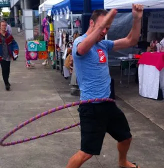 Jason spinning a hula hoop at a farmer's market in Bremerton